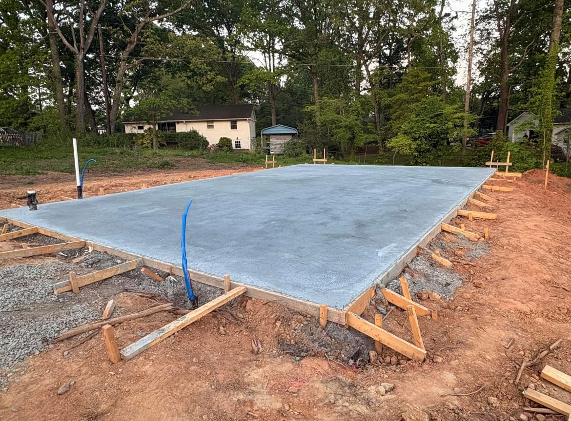 Finished Concrete Foundations job in Charlotte, North Carolina by Local Concrete Co — clean control-joint pattern, smooth troweled surface, full property protection during pour.